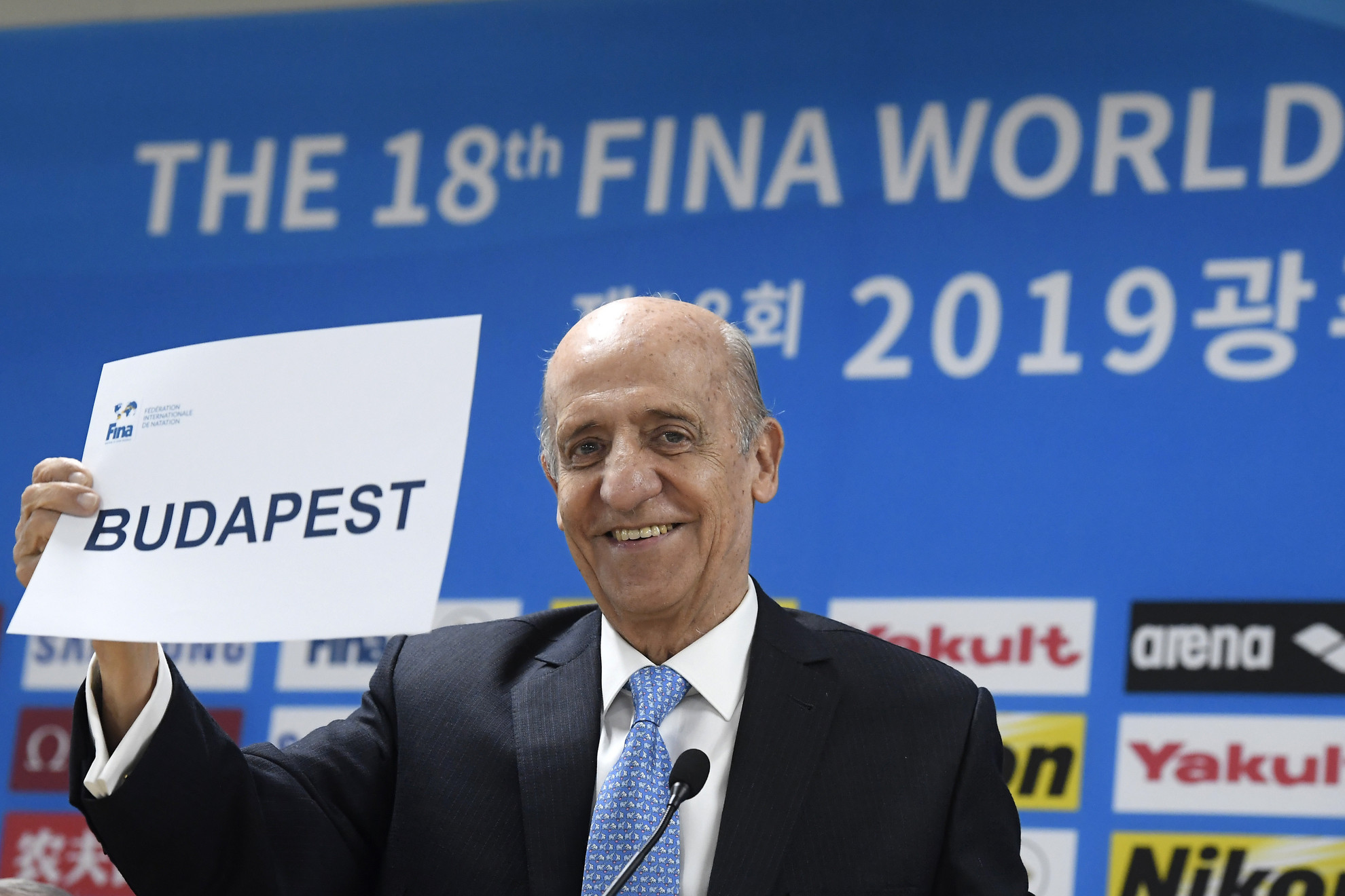 Fotó: MTI/Kovács Tamás Julio Cesar Maglione, a Nemzetközi Úszó Szövetség (FINA) elnöke mutatja: Budapest a 2027-es vb házigazdája