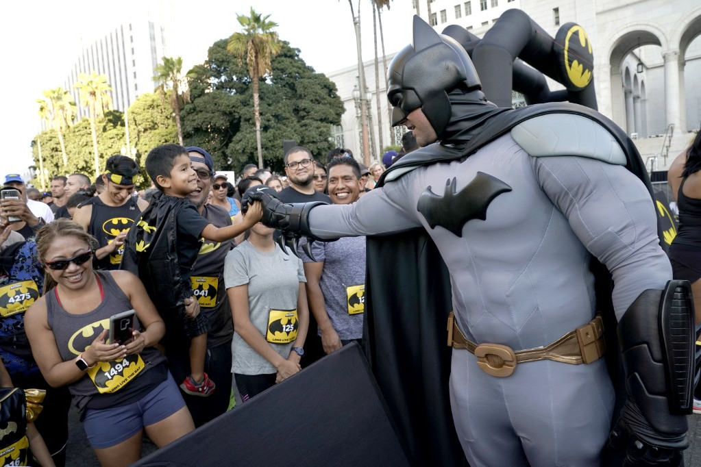 Fotó: AFP/Getty Images North America Batman-jelmezbe öltözött férfi köszönti a Los Angeles-i Batman-futás résztvevőit