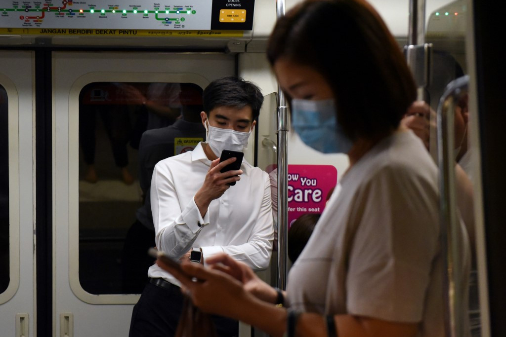 Fotó: Catherine LAI / AFP Maszkban utazók a szingapúri metrón