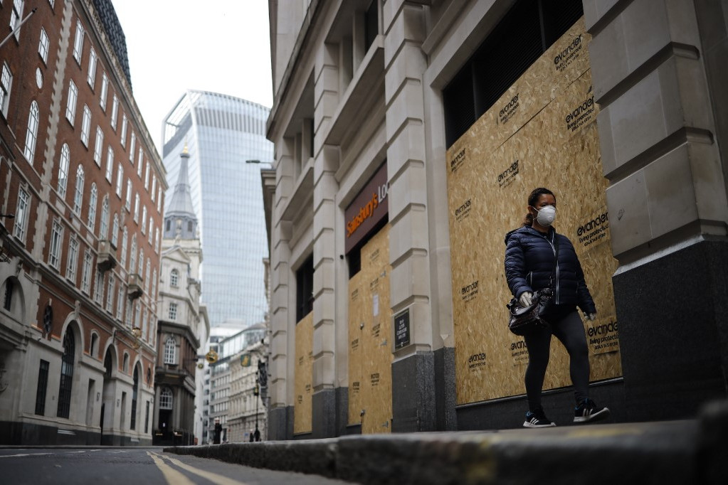 Fotó: Tolga Akmen / AFP Bezárt boltok előtt sétáló nő a szinte kihalt Londonban