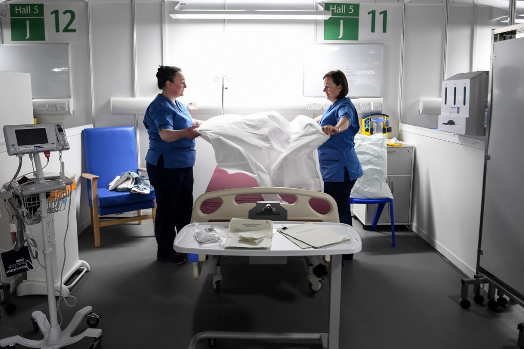 Nővérek készítenek betegfogadásra alkalmas állapotra egy kórházi ágyat Glasgow-ban