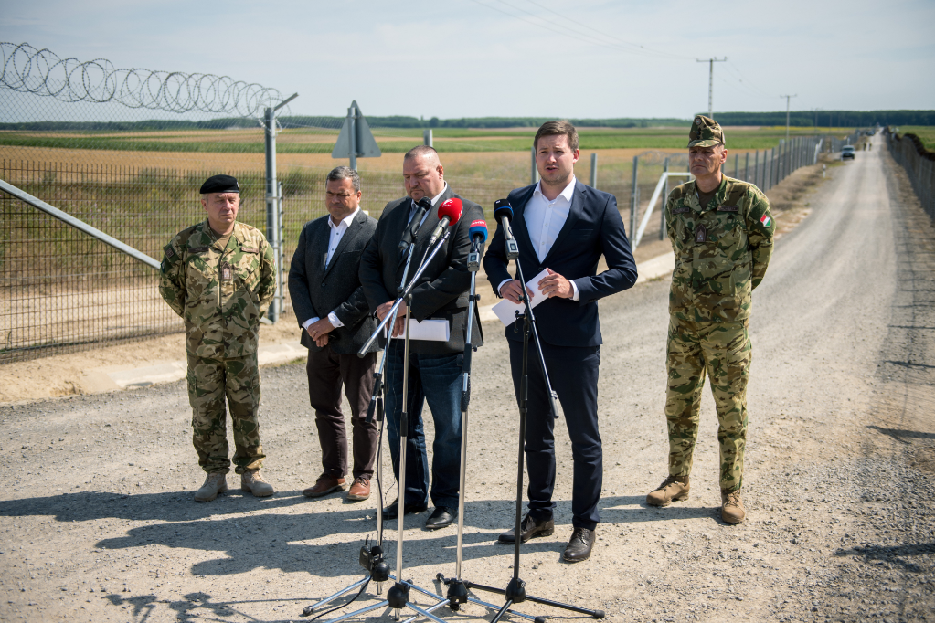 Fotó: MTI/Sóki Tamás Farkas Örs, a Kormányzati Tájékoztatási Központ szóvívője (j2) sajtótájékoztatót tart az ideiglenes biztonsági határzár mellett a bácsalmási magyar-szerb határátkelőhely közelében