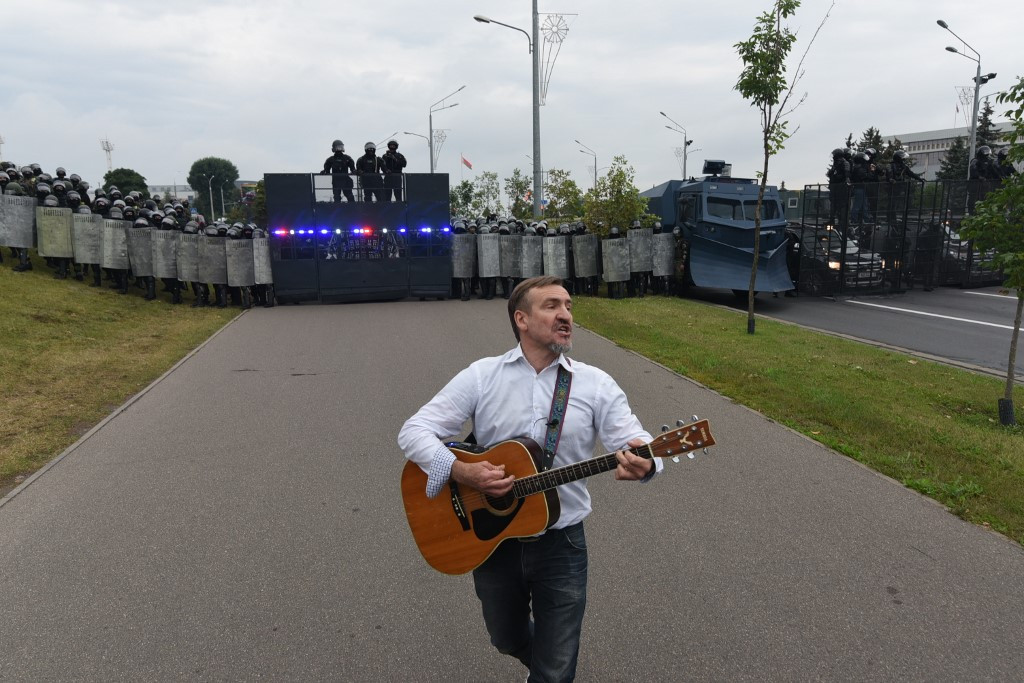 Fotó: Marina Serebryakova / ANADOLU Tüntető gitárral a pajzzsal felszerelkezett rendőri erők sorfala előtt