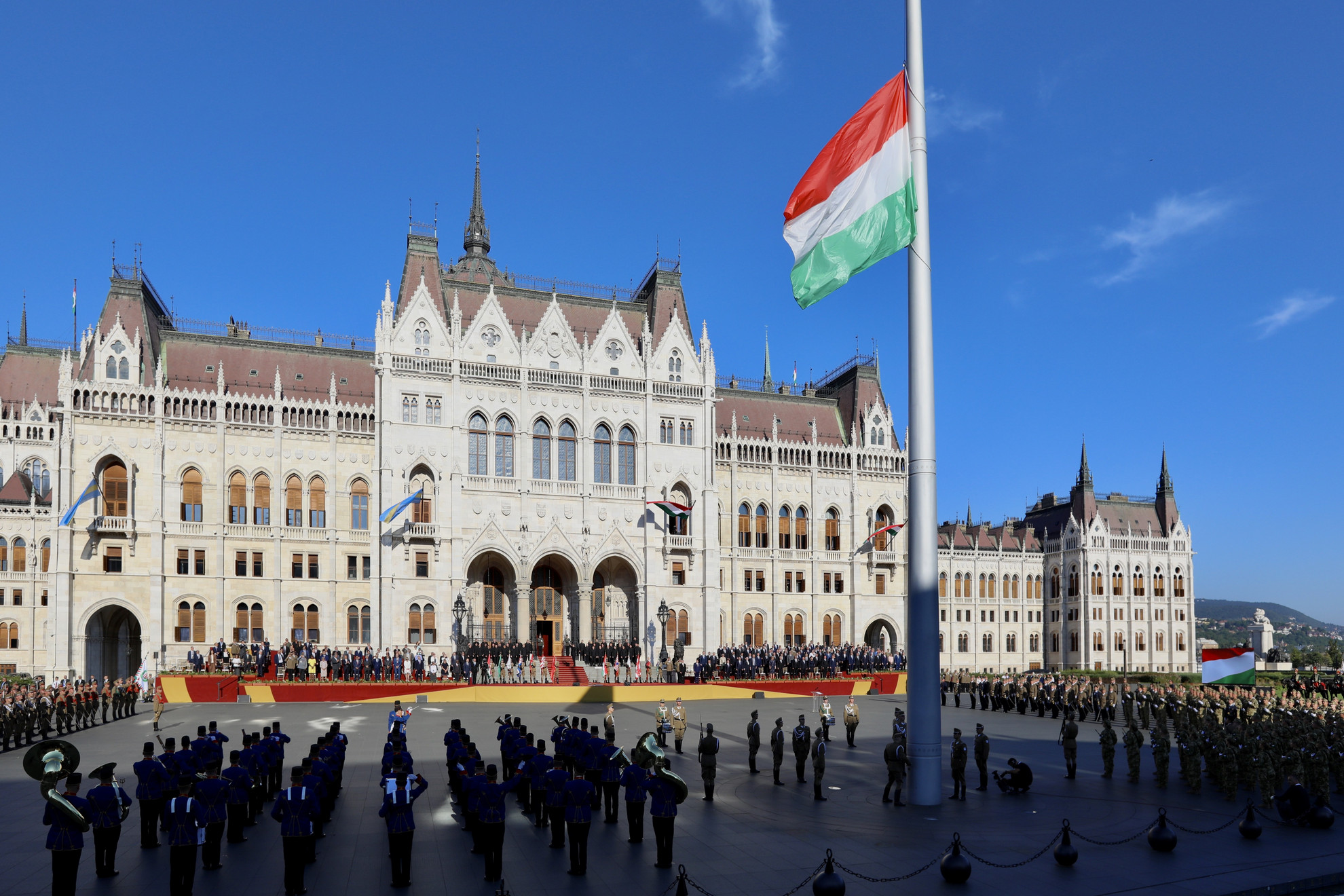 Katonai tiszteletadás mellett, a közjogi méltóságok jelenlétében felvonják Magyarország nemzeti lobogóját az államalapító Szent István király ünnepe alkalmából tartott díszünnepségen és tisztavatáson az Országház előtt, a Kossuth Lajos téren 2020. augusztus 20-án