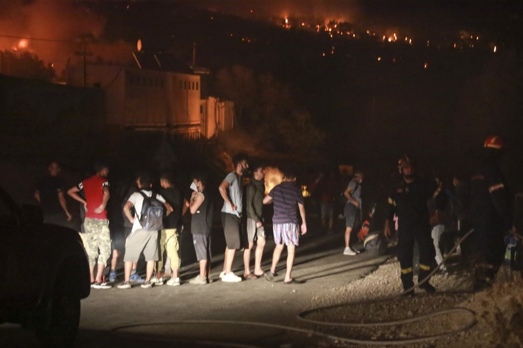 Fotó: AFP/Manolis Lagoutaris Migránsok gyülekeznek a kiürített tábor mellett