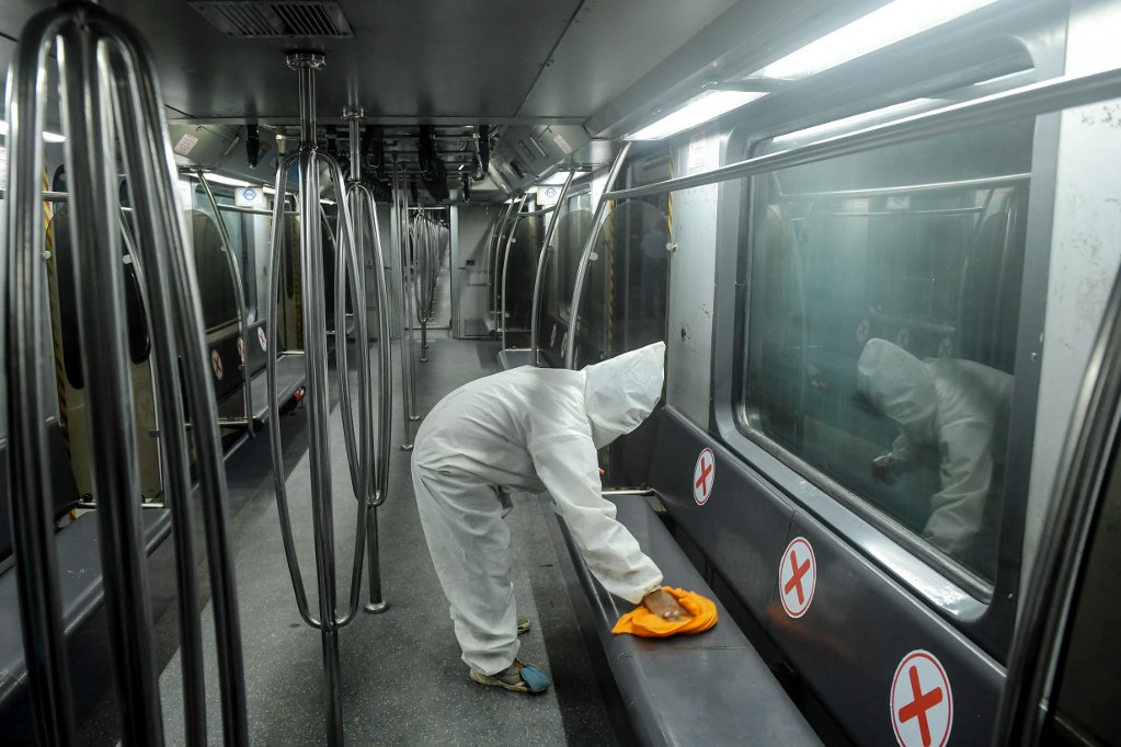 Fertőtlenítést végző egészségügyi dolgozó egy indiai metrószerelvényen