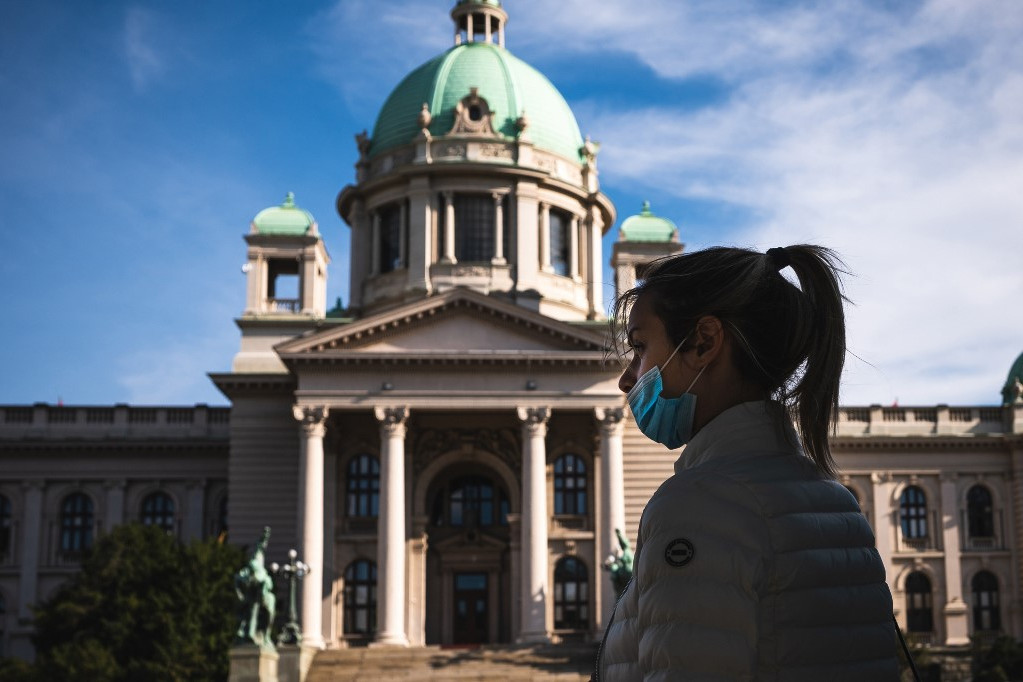 Szerb járókelő szabálytalanul hordja a maszkját Belgrádban