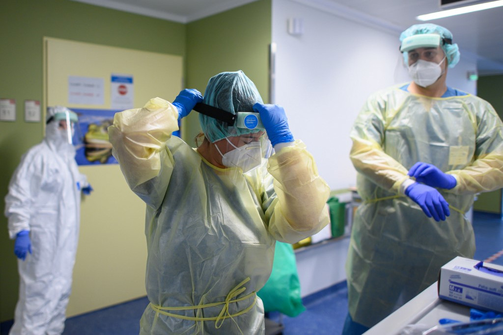 Német egészségügyi dolgozók felveszik védőfelszerelésüket