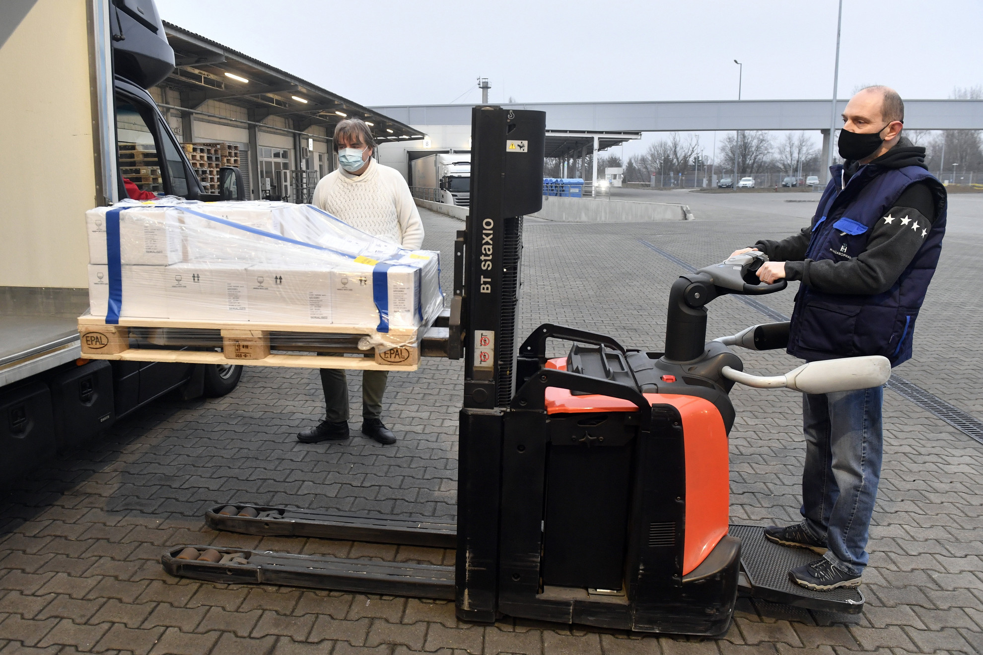 Kirakodják a teherautóból az Európai Gyógyszer Ügynökség által engedélyezett oltóanyag, az oxfordi AstraZeneca-vakcina első szállítmányát a Hungaropharma gyógyszer-nagykereskedelmi vállalat budapesti telephelyén