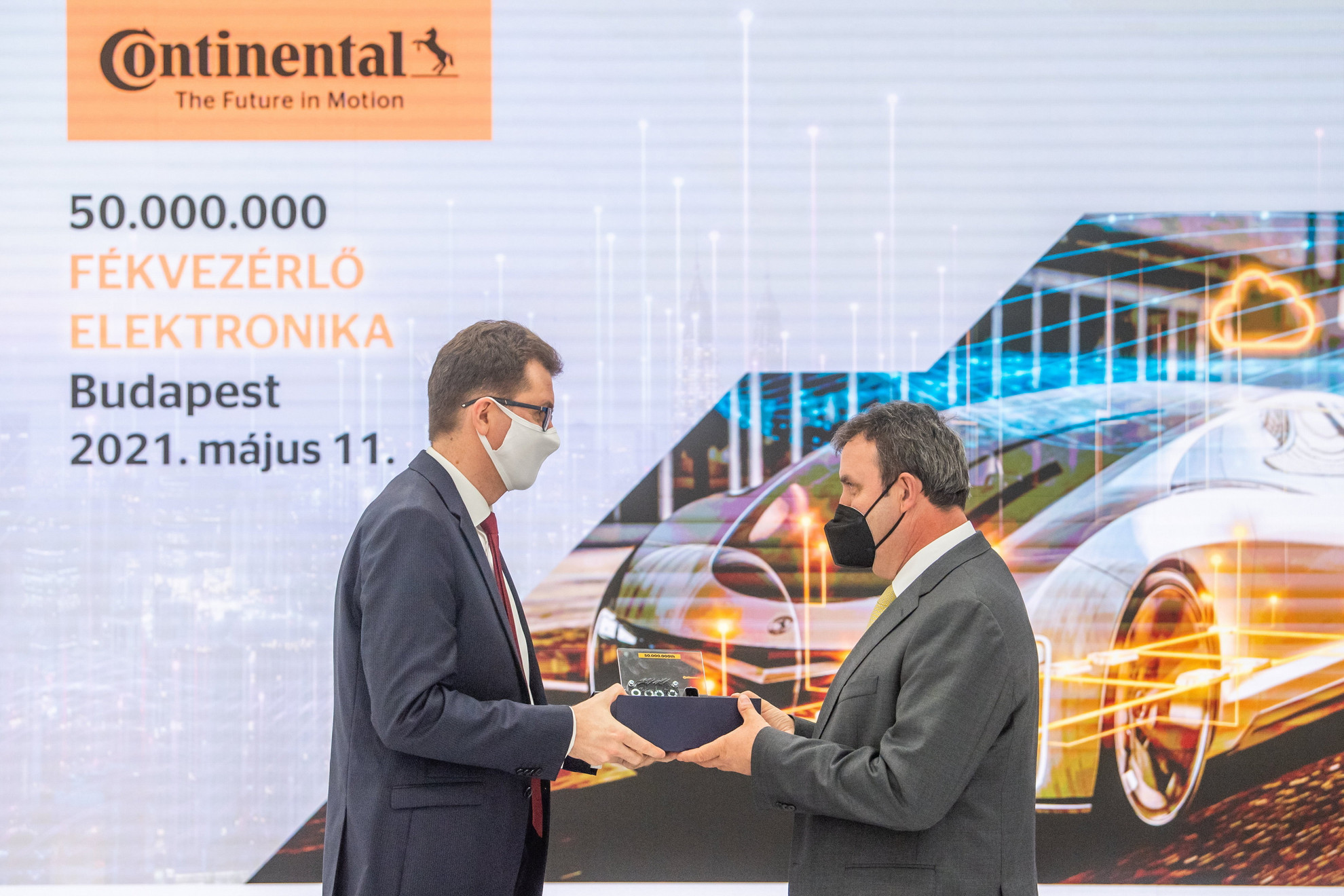 Fotó: MTI/Balogh Zoltán Palkovics László innovációs és technológiai miniszter (j) átveszi az ötvenmilliomodik fékvezérlő elektronikai egységet Keszte Róberttől, a budapesti Continental Automotive Hungary Kft. ügyvezető igazgatójától a kft. fővárosi, X. kerületi üzemcsarnokában 2021. május 11-én