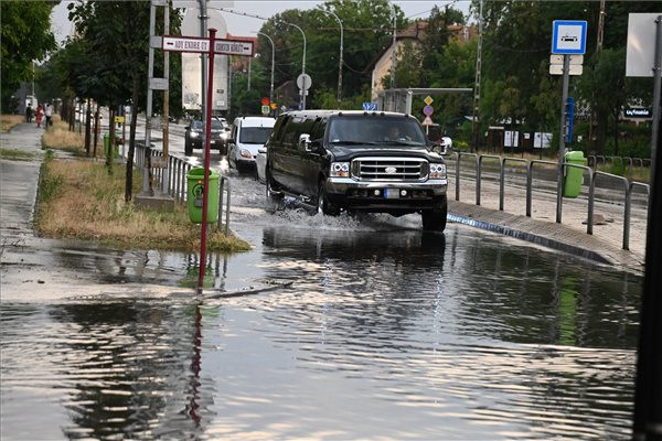 Autók haladnak a felhőszakadás után esővízzel elárasztott úton Budapesten, a XIX. kerületben