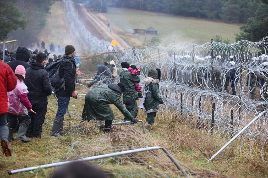Fotó: AFP/BELTA/Leonid Shcheglov Migránsok a lengyel-fehérorosz határt védő kerítésnél