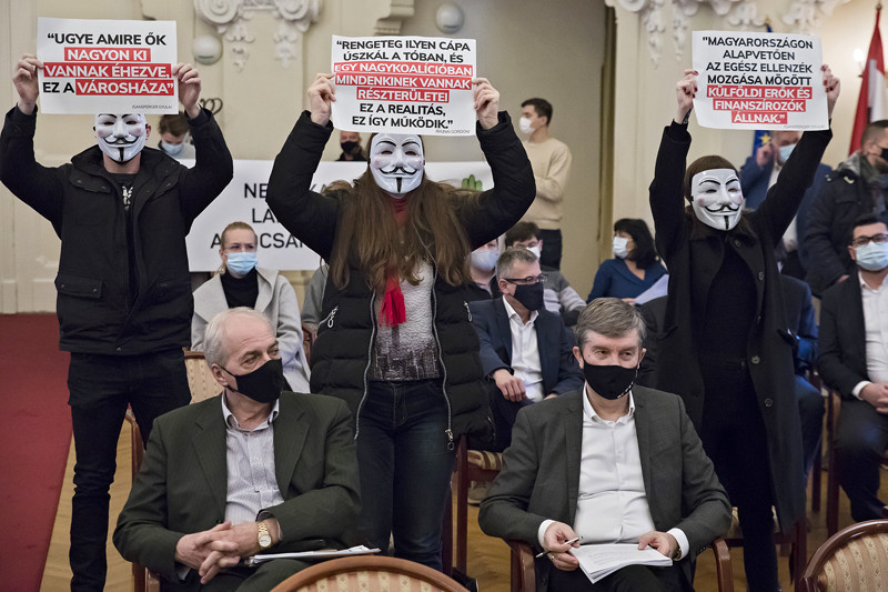 A Városháza-üggyel kapcsolatos transzparenseket mutatnak demonstrálók a Fővárosi Közgyűlés ülésén