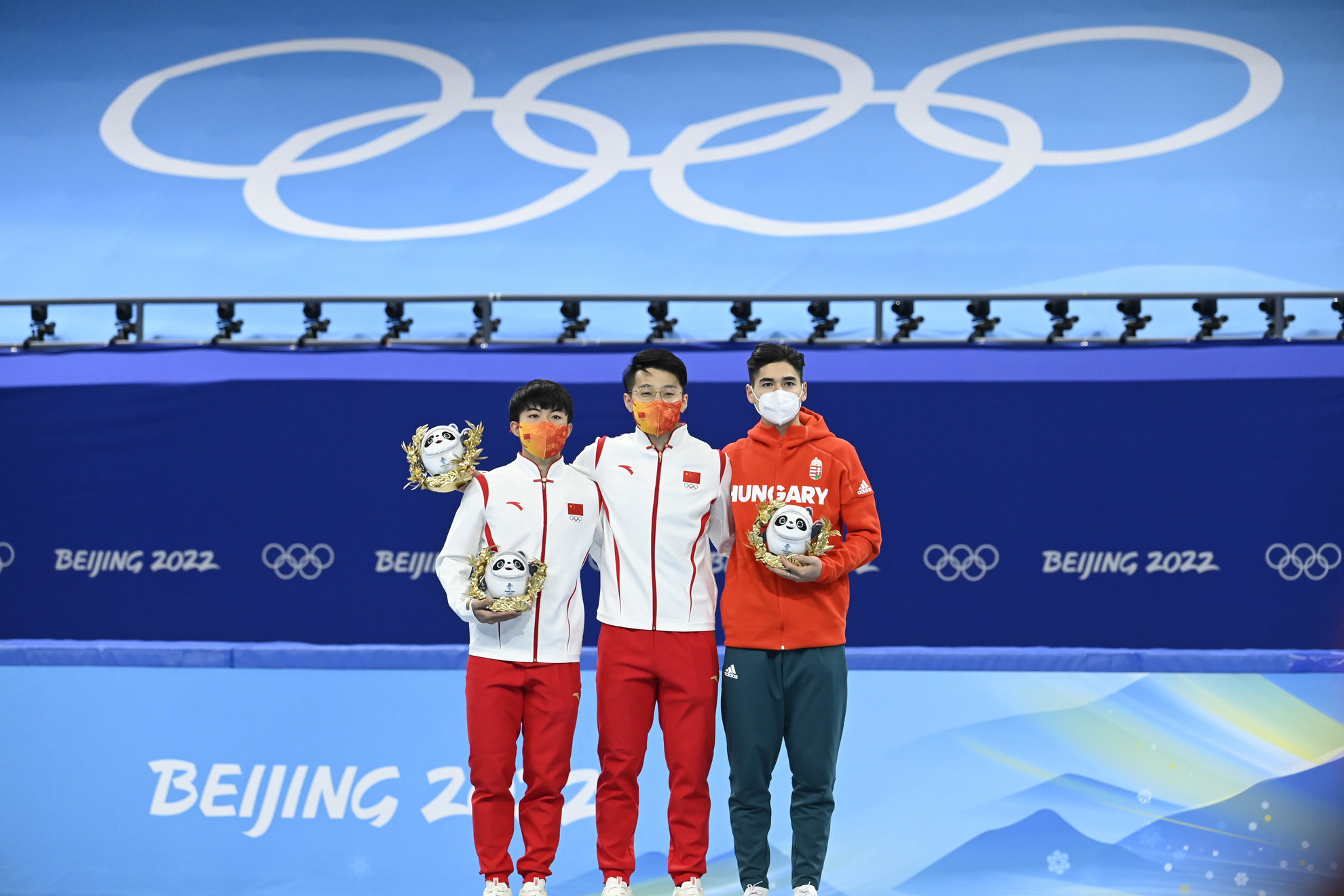 A győztes kínai Zsen Ce-vej (k),  második helyezett honfitársa, Li Ven-lung (b) és a bronzérmes Liu Shaoang (j) a férfi rövidpályás gyorskorcsolyázók 1000 méteres versenyének virágceremóniáján