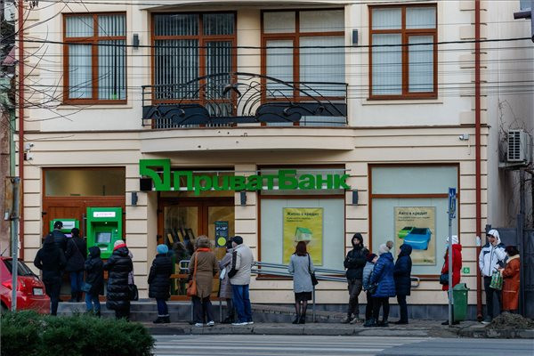 Helyi lakosok állnak sorban pénzfelvételért az ukrán Privat Bank egyik fiókjánál található ATM-nél Ungváron