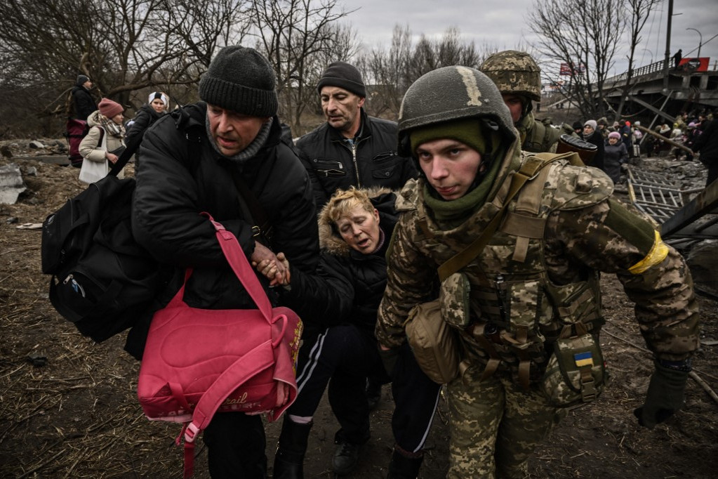 Ukrán katonák segítik a Kijev környékéről menekülő civileket