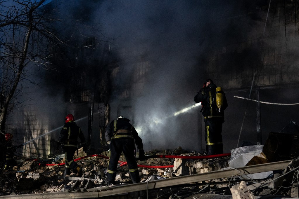 Tűzoltók dolgoznak a romoknál, miután találat érte a kijevi tévétornyot