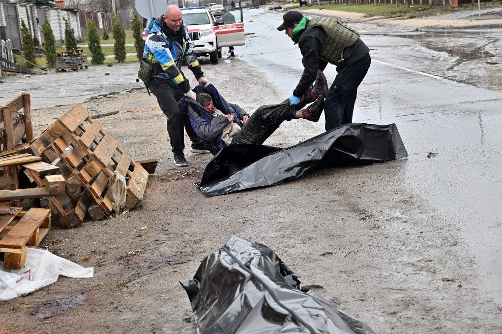Az utcán heverő holttesteket gyűjtik össze Bucsában