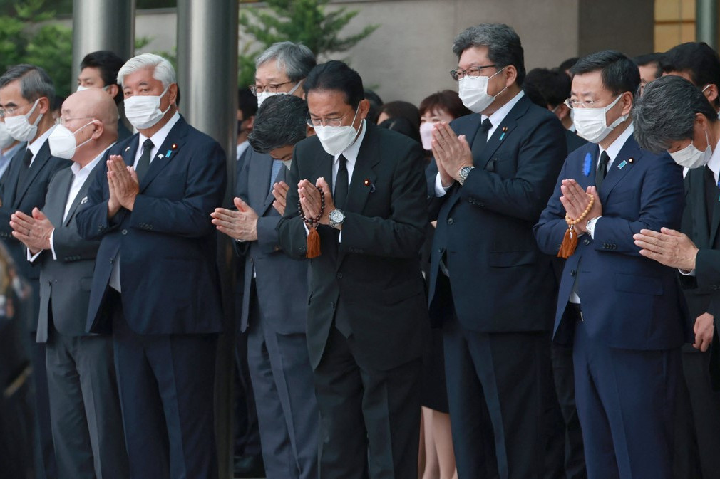 Fotó: AFP/STR/JIJI PRESS A jelenlegi japán miniszterelnök Fumio Kisida (középen) és kormányzati tisztségviselők közösen imádkoznak a gyászszertartáson