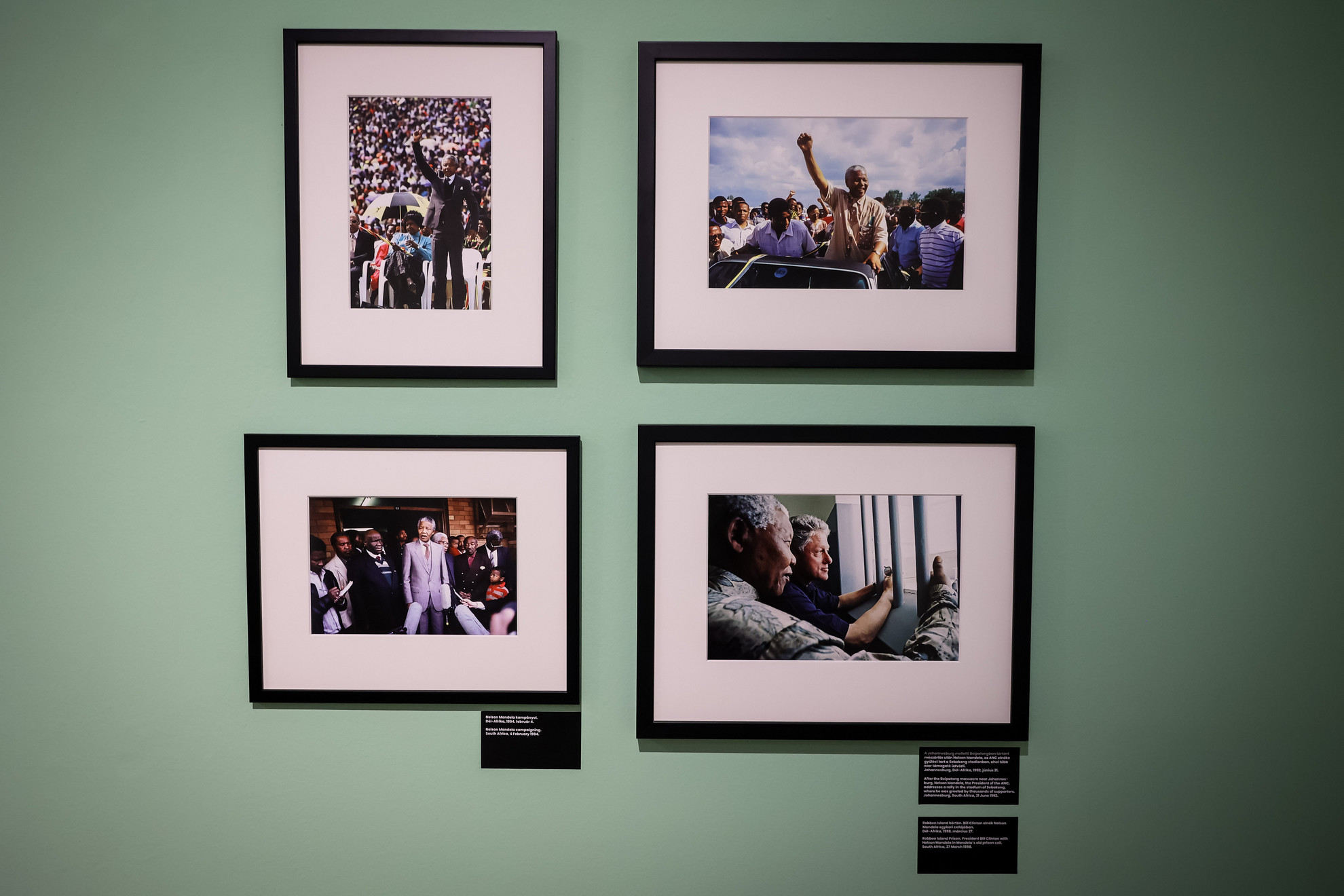 Jobbra lent a híres fotó Mandela és Clinton 1998-as találkozójáról a Robben-szigeten, Mandela egykori cellájában. Ezt a beállítást sokan koppintották