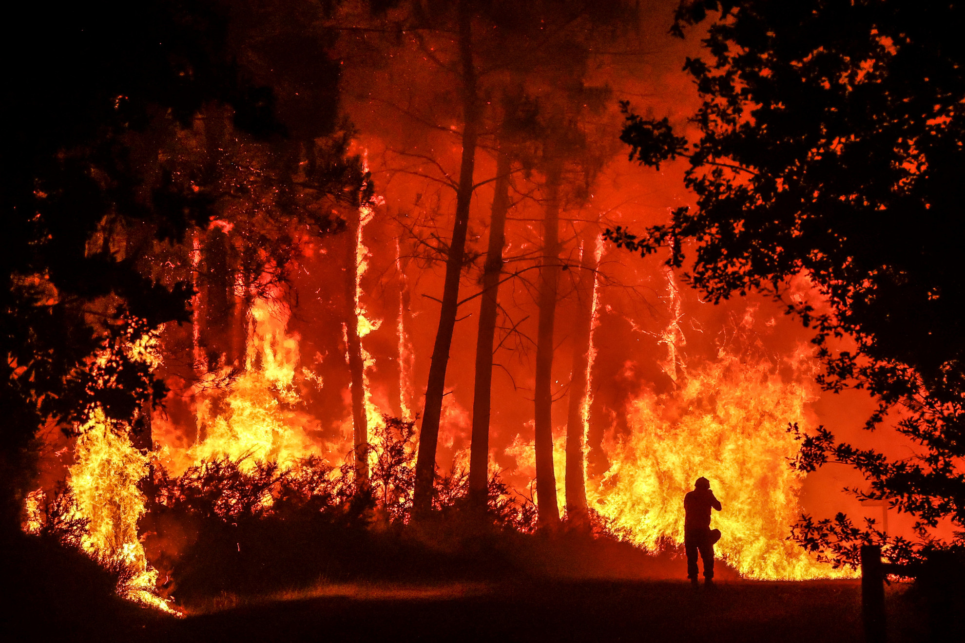 Egy sziluett a lángok előtt a délnyugat-franciaországi Belin-Beliet közelében egy erdőtűzben 2022. augusztus 11-én. Európa több országához hasonlóan Franciaország is egymást követő hőhullámoktól és súlyos aszálytól szenvedett, aminek következtében országszerte számos erdőtűz pusztított.
