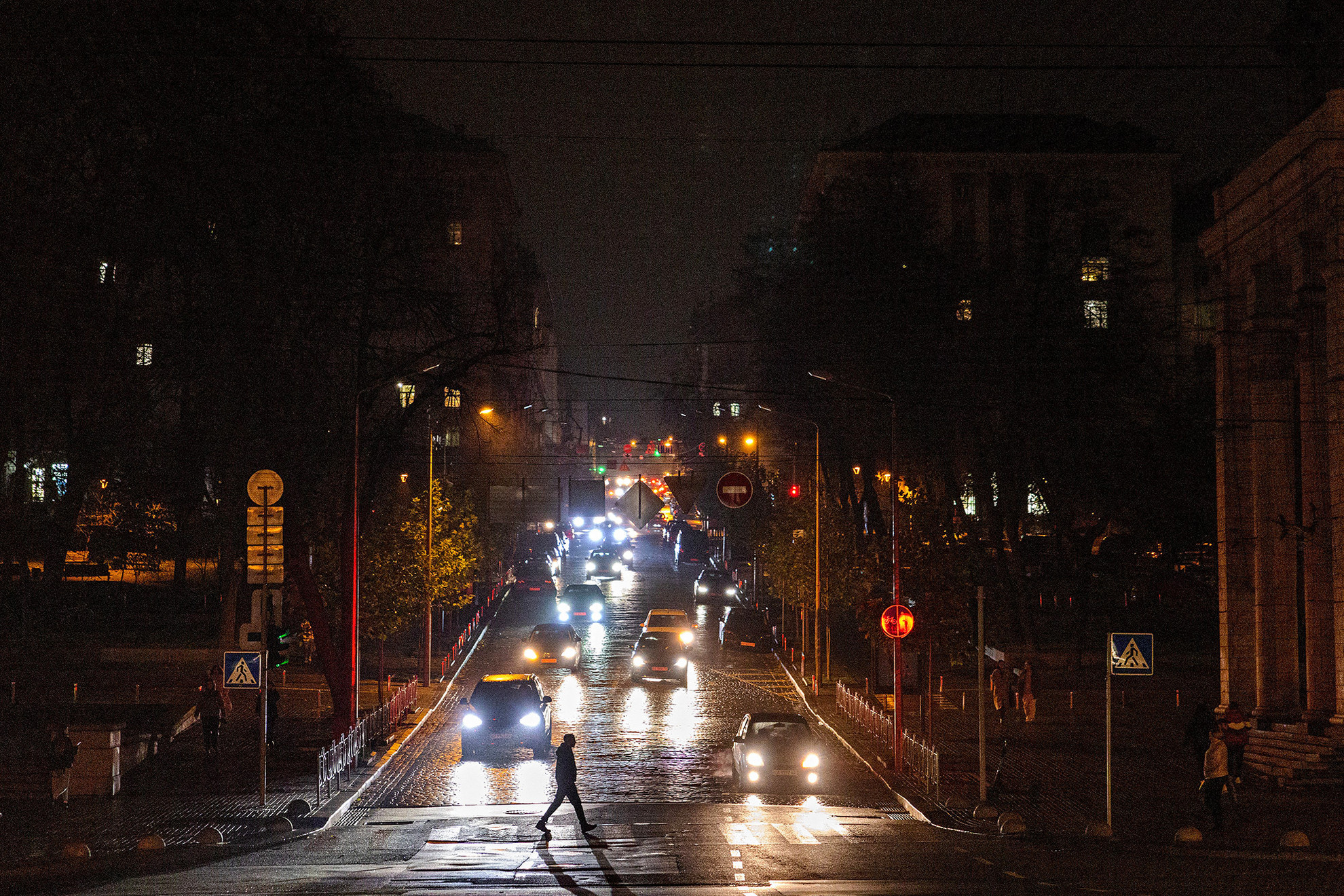 Egy gyalogos átkel egy utcán áramszünet közben Kijev belvárosában, Ukrajna orosz inváziója közepette.