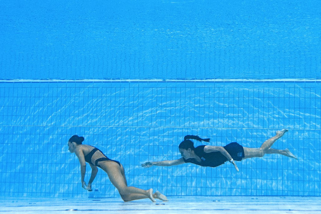 Az amerikai Anita Alvarez (balra) rosszul lett és elveszítette az eszméletét a vízben a női szóló szinkronúszás döntőjében a 2022-es budapesti vizes világbajnokságon. Tíz másodpercig eszméletlen volt, amikor edzője, Andrea Fuentes (jobbra) beugrott utána és kimentette a medencéből a budapesti Hajos Alfréd Uszodában 2022. június 22-én.