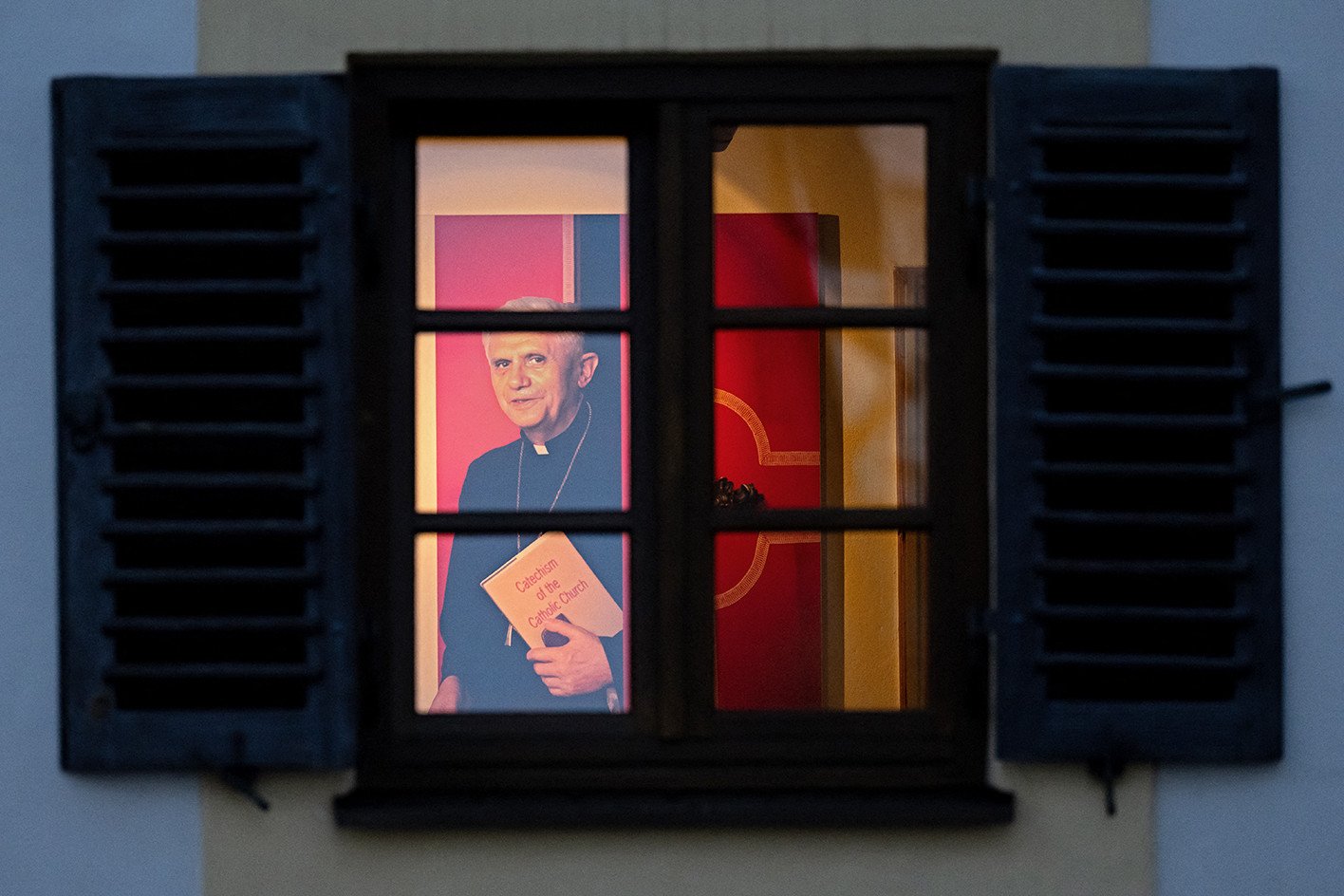 XVI. Benedek emeritus pápának már csak az arcmása néz ki a szülőháza ablakán egy ott nyílt kiállításon.