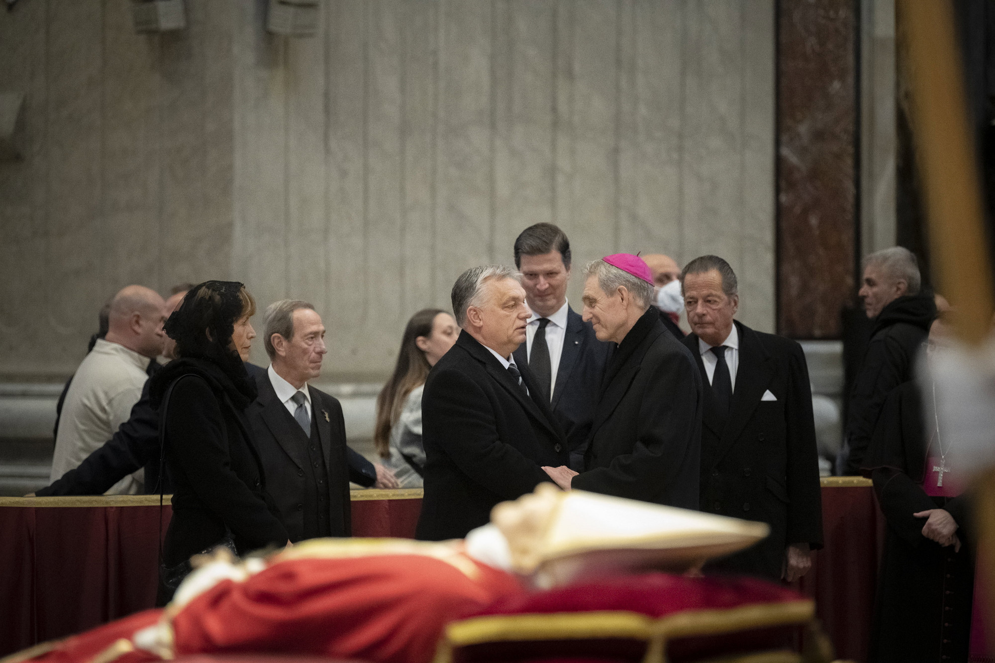 Fotó: MTI/Miniszterelnöki Sajtóiroda/Benko Vivien Cher A Miniszterelnöki Sajtóiroda által közreadott képen Orbán Viktor miniszterelnök (k) és felesége, Lévai Anikó (b) lerója kegyeletét a december 31-én elhunyt XVI. Benedek nyugalmazott pápa ravatalánál Rómában, a Szent Péter-bazilikában 2023. január 3-án. Jobbra Georg Gänswein érsek, mögöttük Habsburg-Lotharingiai Eduárd Károly, Magyarország vatikáni nagykövete (k, hátul).
