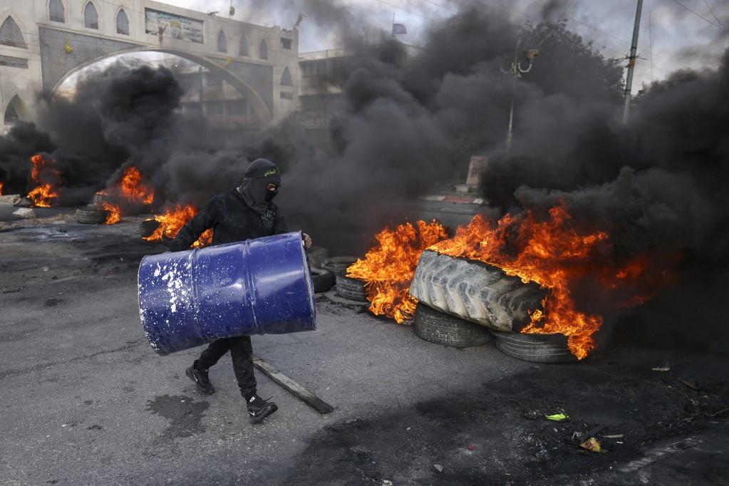 Palesztin tüntetők gumiabroncsokat égetnek el, hogy elzárják a Jerikóba vezető utat a megszállt Ciszjordániában 2023. február 6-án, miután az izraeli erők rajtaütést hajtottak végre a városba