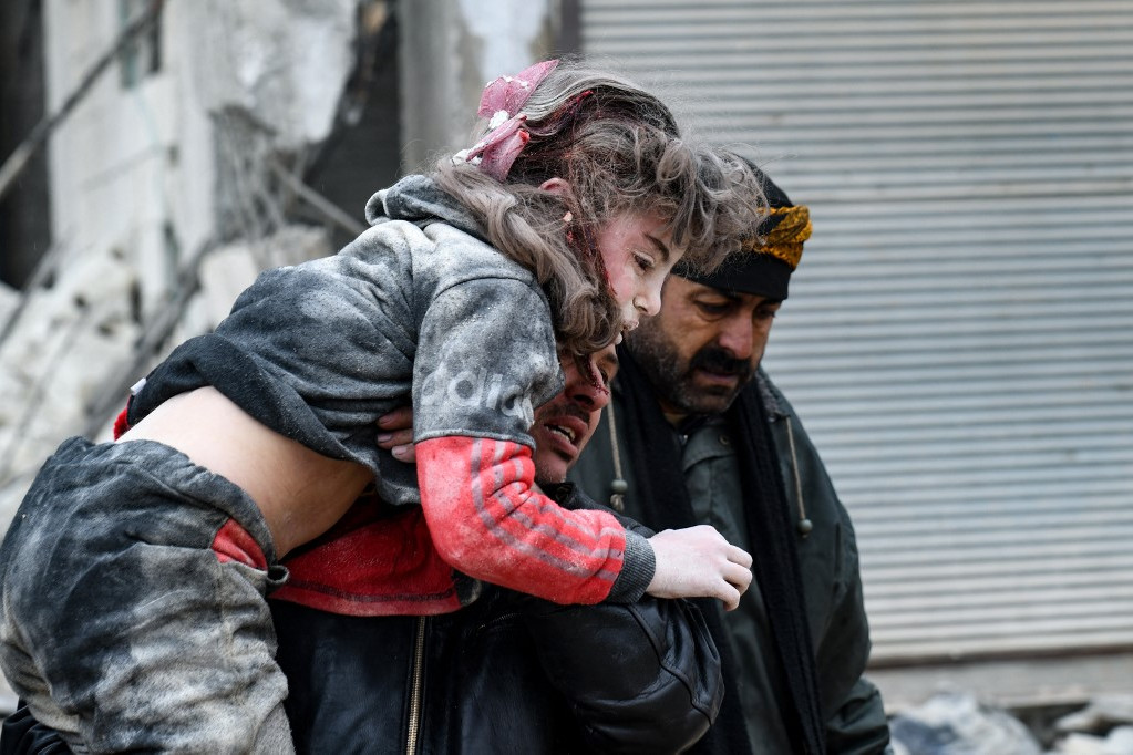 Sérültek mentése egy összedőlt épület romjai közül Jandaris városában, Szíria északnyugati részén, Aleppó tartomány lázadók által birtokolt részén