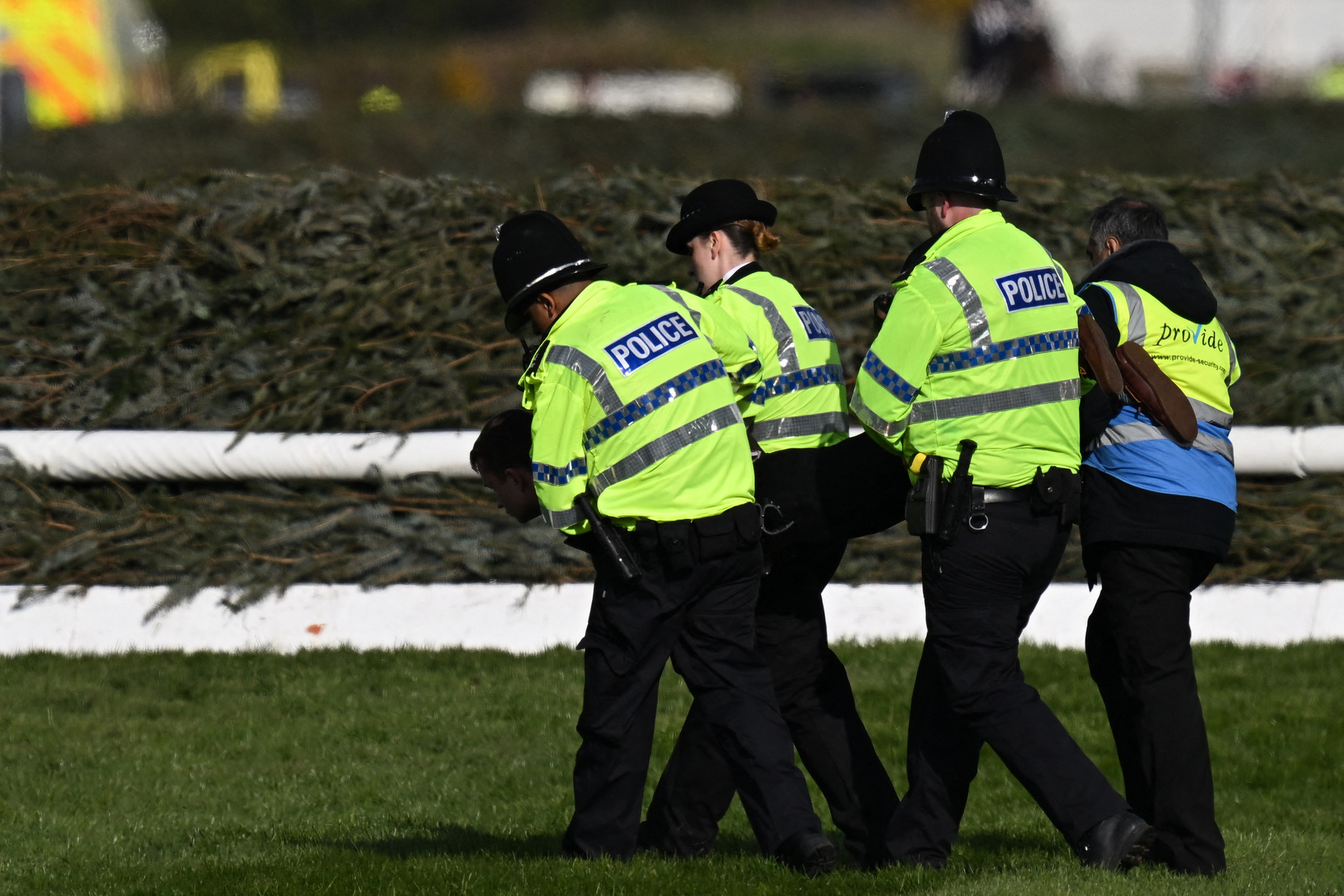 Fotó: AFP/Paul Ellis Egy állatvédőt visznek le a pályáról a brit rendörök