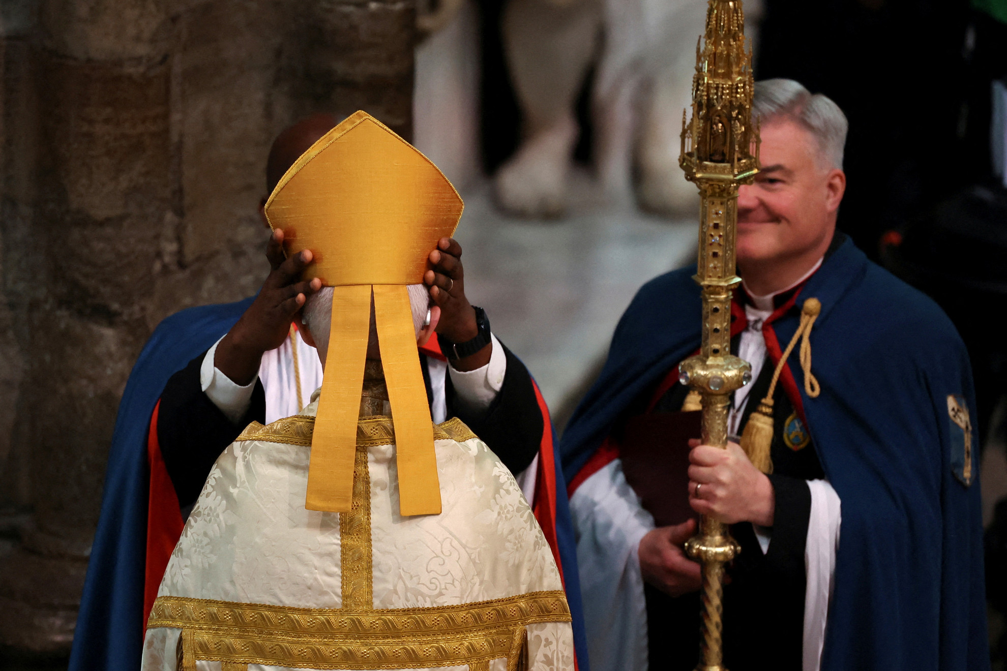 Fotó: AFP/POOL/Phil Noble A mitrát Justin Welby canterburyi érsek fejére helyezik a koronázás előtt a Westminster apátságban