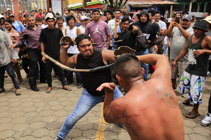 Fotó: AFP/Stringer Videón, ahogy szárított bikapénisszel korbácsolják egymást az emberek Nicaraguában