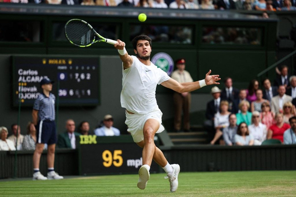 A spanyol Carlos Alcaraz visszaadja a labdát a szerb Novak Djokovicnak a 2023-as wimbledoni teniszbajnokság utolsó napján rendezett férfi egyes döntő mérkőzésen a délnyugat-londoni Wimbledonban