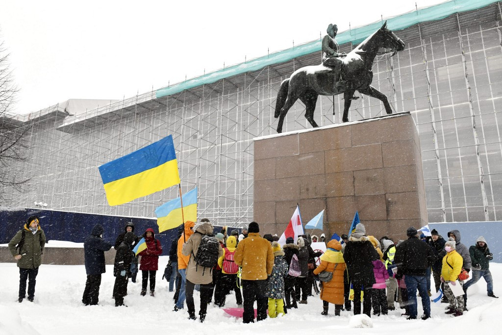 Tüntetők ukrán zászlókkal a „Támogatjuk Ukrajnát” tüntetésen a volt finn elnök, Carl Gustaf Mannerheim marsall szobránál Helsinki központjában 2022. február 5-én