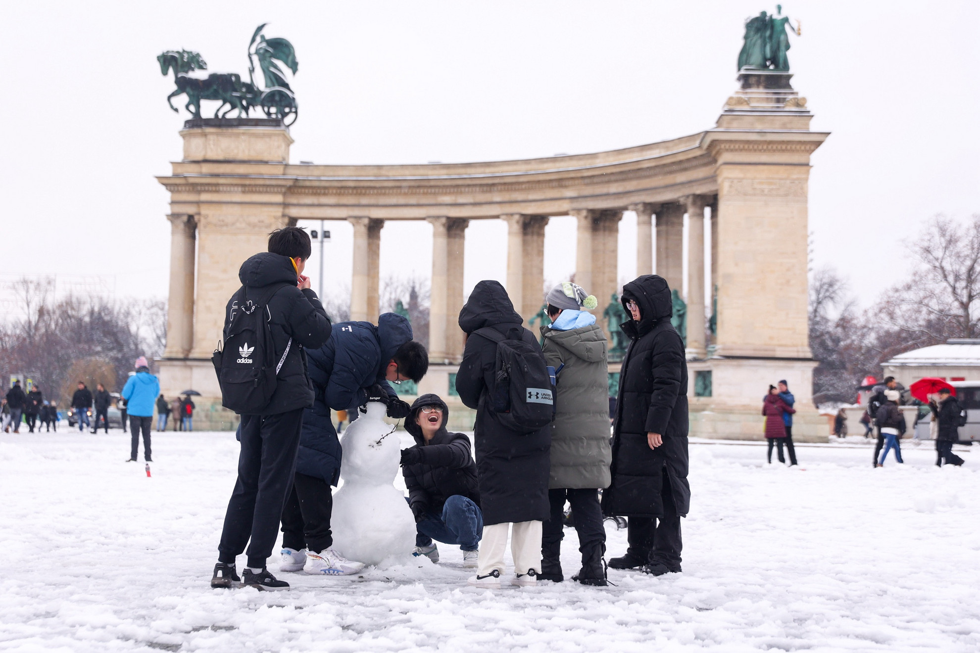 Fotó: MH/Török Péter A turisták is élvezik a frissen esett hó művészeti lehetőségeit a budapesti Hősök terén