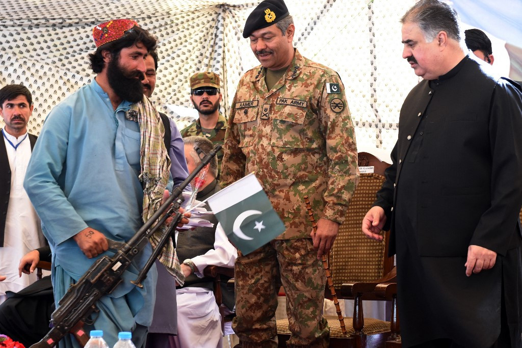 Fotó: AFP/Banaras Khan Egy beludzs lázadó megadja magát 2017-ben Kvettában. A fegyver átvevője Sardar Sanaullah Khan Zehri, a pakisztáni Beludzsisztán tartomány főminisztere. A hivatalos aktuson kereken félezer militáns szabadult meg a gyilkos eszközeitől