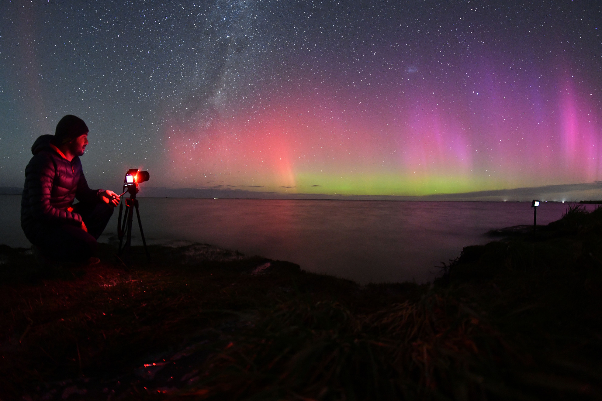 Fotó: AFP/Sanka Vidanagama Aurora Australis, más néven déli fény ragyog a horizonton az Ellesmere-tó vize felett Christchurch külvárosában 2023. április 24-én