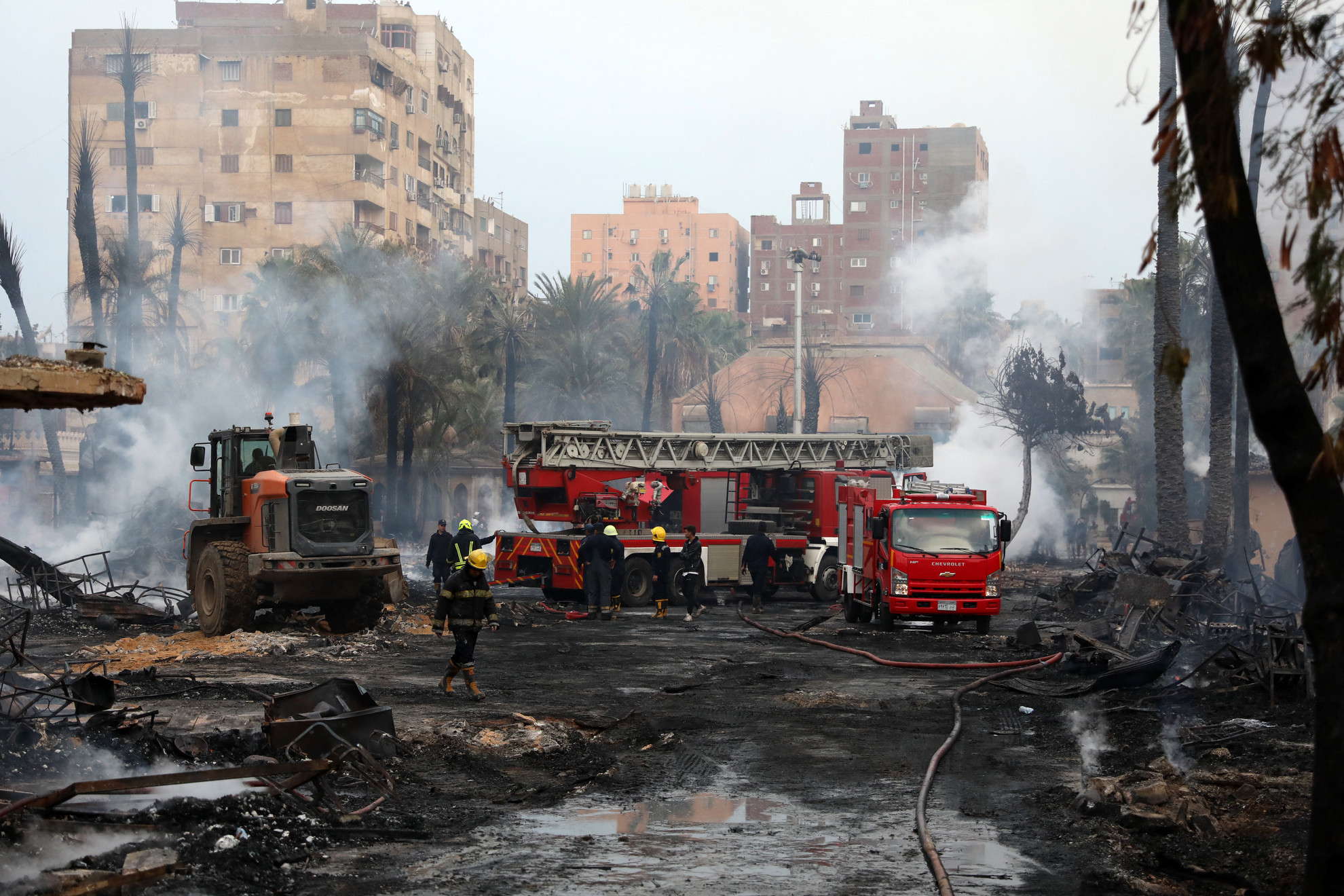 Tűzoltók hűtik a még mindig parázsló területet az Al-Ahram stúdióban és a környező épületekben keletkezett tűz után Kairó Gízai kerületében 2024. március 16-án. A lángok elborították az arab világ egyik legrégebbi és legrangosabb, 80 évvel ezelőtt alapított filmgyártó stúdióját, mindent felégettek benne, és átterjedtek három környező épületre, amelyeket evakuáltak, mielőtt a tűz elérte volna őket