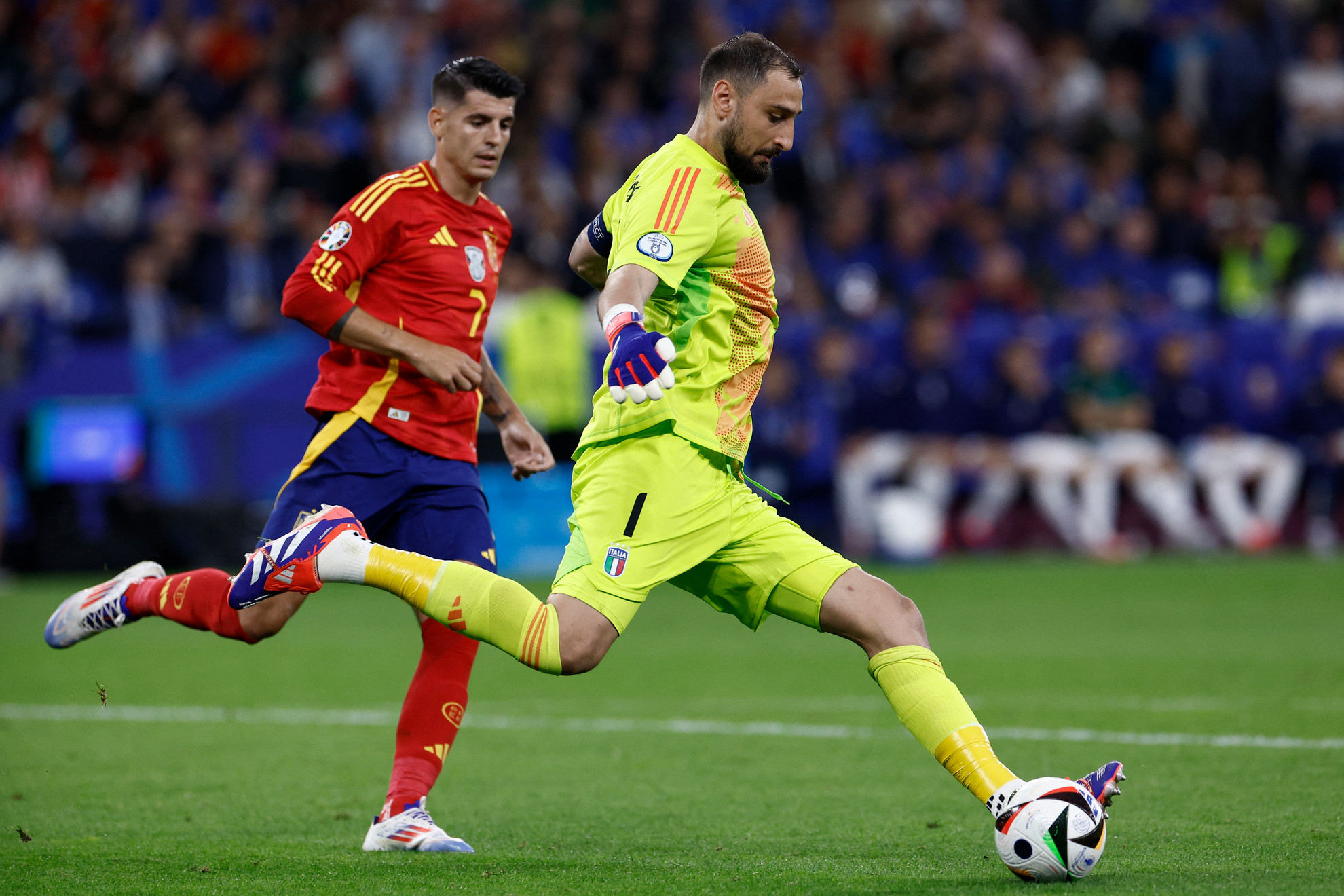 Az olaszok kapusa, Gianluigi Donnarumma (j.) a spanyol Alvaro Morata mellett rúgja el a labdát a Spanyolország–Olaszország érkőzésen