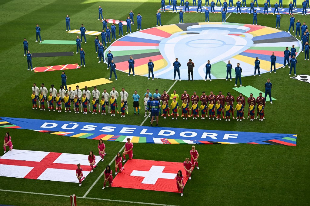 Anglia (balra) és Svájc (jobbra) válogatott játékosai az Euro 2024 negyeddöntő labdarúgó-mérkőzés előtt a Düsseldorf Arénában 2024. július 6-án