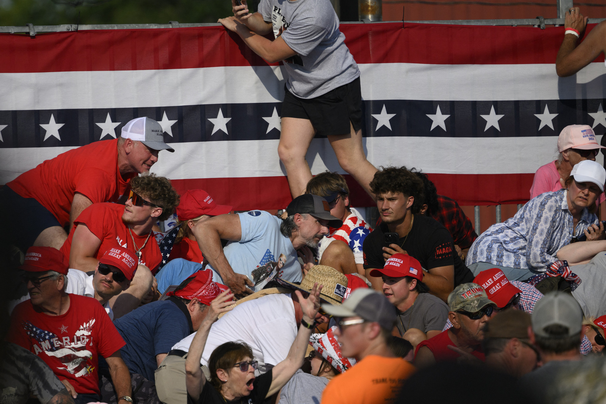 Fotó: Getty Images via AFP/JEFF SWENSEN Emberek menekülnek a lövések elől, miután rálőttek Donald Trump volt amerikai elnökre a Butler Farm Show Inc. épületében 2024. július 13-án a pennsylvaniai Butlerben