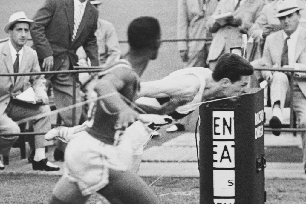 Az Otis Davis (L)and German Carl Kaufmann cross together the finish line