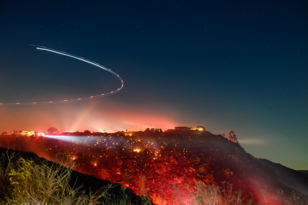A hosszú expozíciójú felvételen egy helikopter vizsgálta a helyszínt a kaliforniai San Diego megyében, 2025. január 21-én a Lilac tűzvész idején