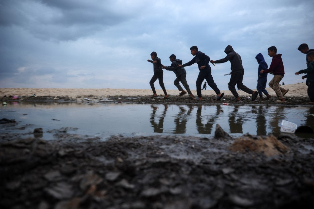 A fegyverek elhallgattak, a kitelepített palesztin gyerekek önfeledten játszhatnak a sátrak mellett Deir el-Balahban, a Gázai övezet középső részén 2025. január 22-én, az Izrael és a Hamász között kötött tűzszüneti megállapodás negyedik napján
