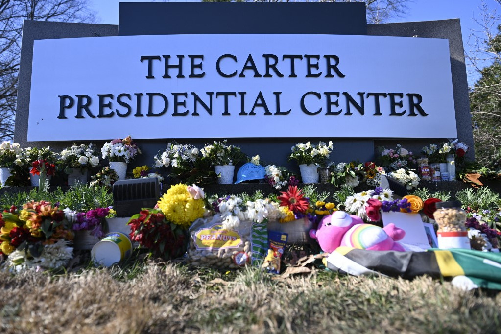 Virágok Jimmy Carter volt amerikai elnök emlékművénél, a georgiai Atlanta állambeli Carter elnöki központ előtt 2025. január 4-én