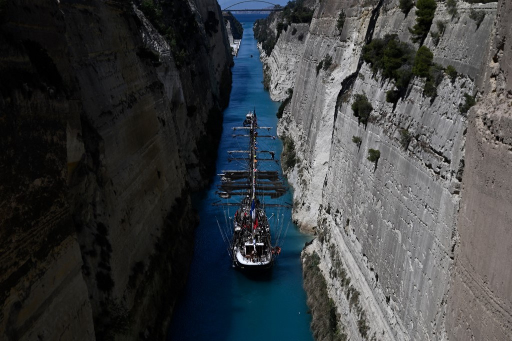 Fotó: Aris MESSINIS / AFP A 19. századi francia háromárbocos barque Belem áthajózik a Korinthoszi-csatornán, egy nappal azután, hogy kihajózott az Athén melletti Pireusz kikötőjéből, az olimpiai lánggal a fedélzetén.