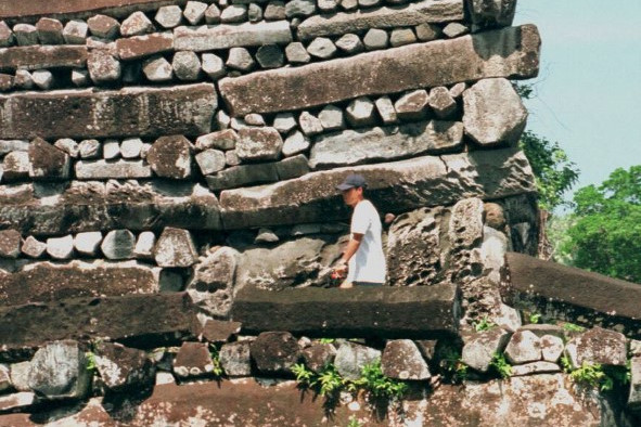Egy turista elsétál a fő erőd egyik sarka mellett Nan Madol elhagyatott városában, Pohnpei szigetén, a Mikronéziai Szövetségi Államokban.