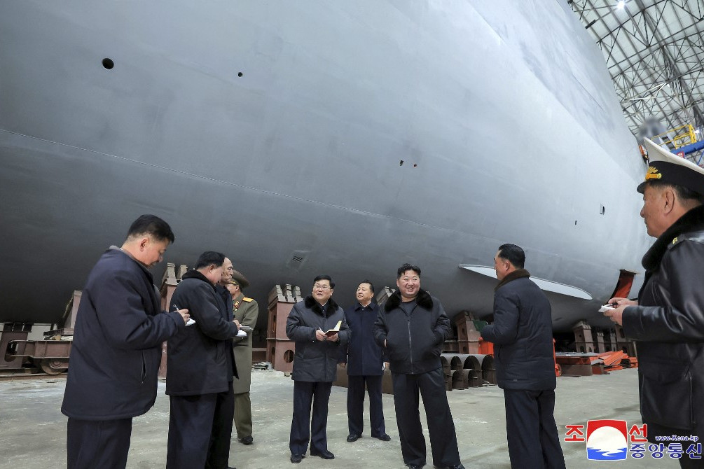 Fotó: AFP/KNS/KCNA/STR Kim Dzsong Un észak-koreai vezető (3. j) még a hajógyárban ellenőrizte vízre bocsátása előtt a tengeralattjárót